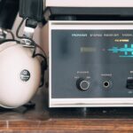 Immagine di un mercato vintage con elettronica retrò in vendita, tra cui radio e console di gioco.