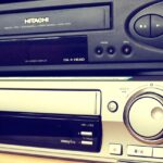 Mercatino dell'elettronica con oggetti tech vintage in esposizione, tra cui radio e console di gioco.