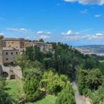 Panorama suggestivo dell'Umbria con sentiero di cammino spirituale immerso nella natura.